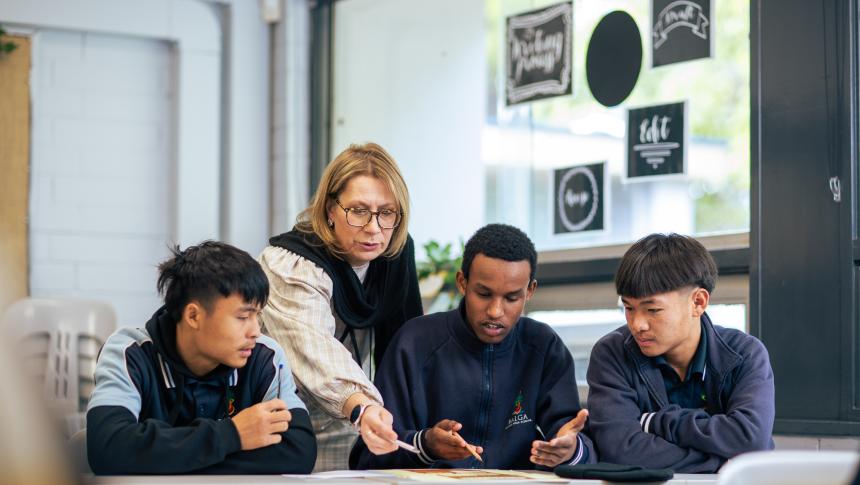 teacher helping three students