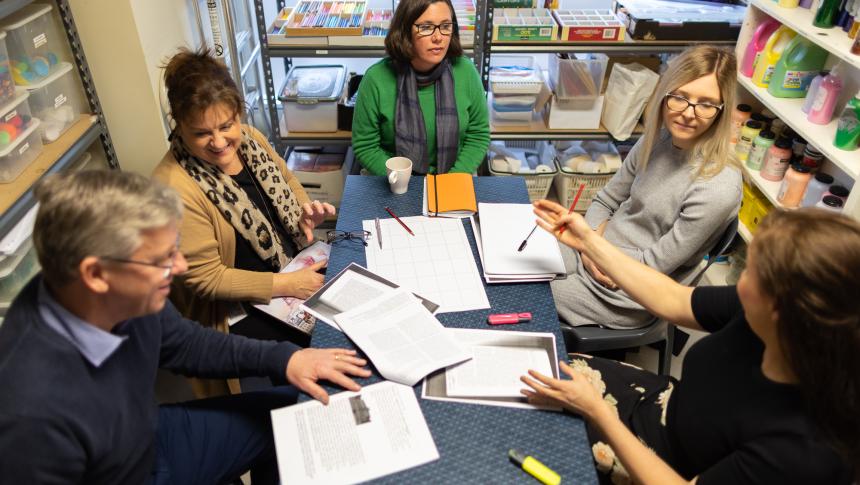 Group of adults sitting around a table discussing documents