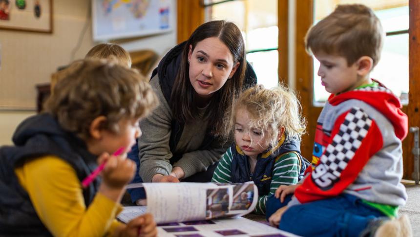 An educator with three preschool students. 